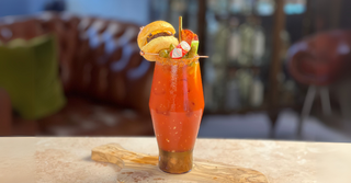 Ultimate Bloody Mary Cocktail Recipe, made with Olive Oil Vodka. Complete with burger slider, bacon, olives and pickles.