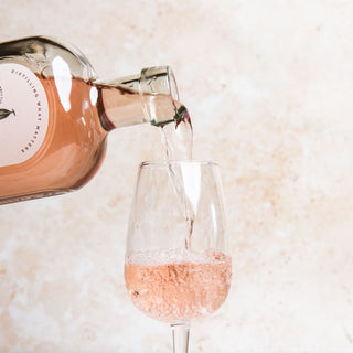 58 and CO Apple and Hibiscus Pink Gin bottle being poured into a glass with a soft, blurred background