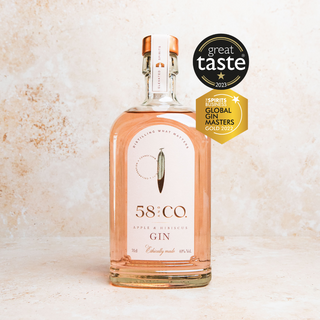 Bottle of 58 and CO Apple & Hibiscus Pink gin with 'Great Taste' and 'Global Gin Masters' awards on a light background