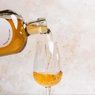 Bottle of 58 and CO British Bianco Vermouth 2024 | CO-LAB Series with Laylo | English Vermouth | White Vermouth pouring a drink into a glass on a light background