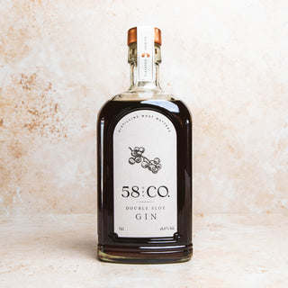 Bottle of  58 and CO Double Sloe Gin on a textured beige background