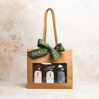 Miniature Gin Gift Set - Gift Wrapped in a bag with 58 and CO Branded ribbon tied in a bow on a textured beige background