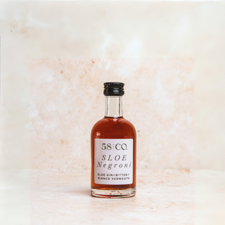 Mini bottle of 58 and Co. Sloe Negroni on a light marble background