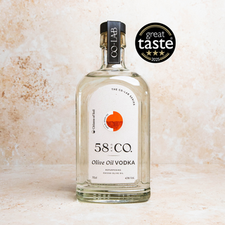 Bottle of 58 and Co Olive Oil Vodka Spain with a 'Great Taste' award on a textured beige background