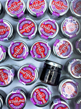 Hotel Starlino Italian Maraschino Cocktail Cherries (42g Mini Jars) showing lids and one jar on the side