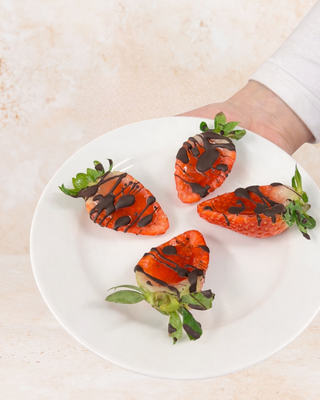 Strawberry Kisses - Valentine’s Strawberry Vodka Jelly Shots on a white plate with a beige textured background