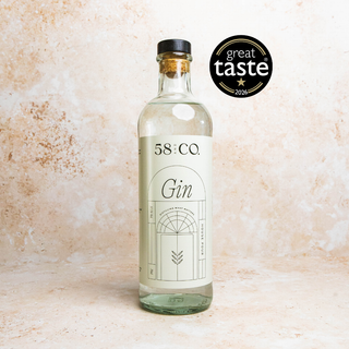 Bottle of 58 and CO House Pour Gin on a textured beige background with Great Taste Award bage