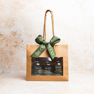 Mini Martini Gift set with three bottles and a green ribbon on a beige background