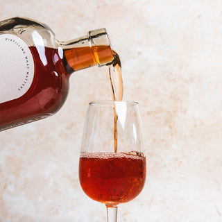 Bottle of Bottle of 58 & Co. British Red Bitter being poured into a glass on a light background
