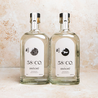 Two bottles of 58 and CO. Shochu on a textured beige background