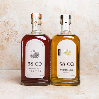 Two bottles of 58 & Co. British Red Bitter and Vermouth on a textured surface.