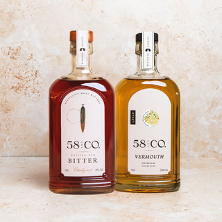 Two bottles of 58 and CO Red Bitter and Bianco Vermouth on a textured surface