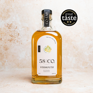 Bottle of 58:CO Vermouth with a 'Great Taste' award badge on a textured beige background