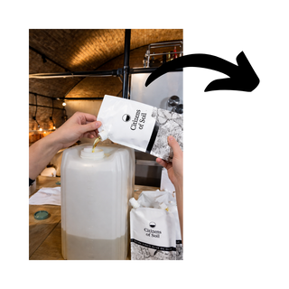 Person pouring olive oil from a bag into a white container with 'Citizens of Soil' branding.