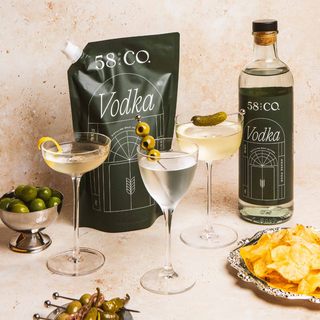 58 and CO House Pour Vodka bottle and refill pouch with cocktails and snacks on a table
