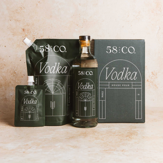 Collection of 58 and CO House Pour Vodka products on a beige background - glass bottle, refill pouch, mini travel pouch and refill box