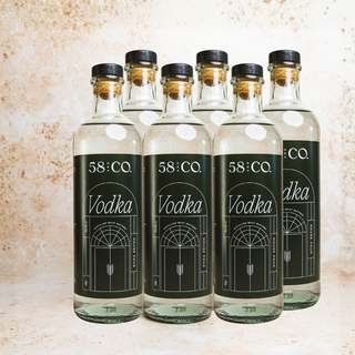 Six bottles of 58 and CO Vodka on a textured surface