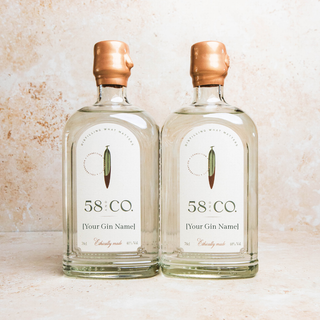 Two bottles of 58 AND CO. Personalised  gin on a textured surface