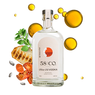 A bottle of 58 and CO. Olive Oil Vodka centered on a white background, surrounded by olive oil droplets, sliced tomatoes, toasted bread, and green herbs.
