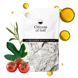 Citizens of Soil Extra Virgin Olive Oil Club Pouch pouch on a white background, styled with olive branches, green leaves, red tomatoes, and floating golden oil droplets.
