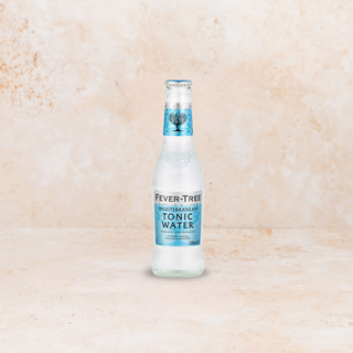 Fever-Tree Mediterranean tonic water bottle on a beige marble background