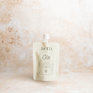 Mini travel pouch of 58 and CO House Pour Gin on a textured beige background