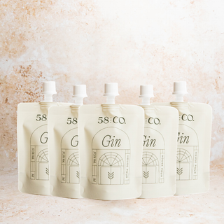 Five mini travel pouches of 58 and Co House Pour Gin on a light background