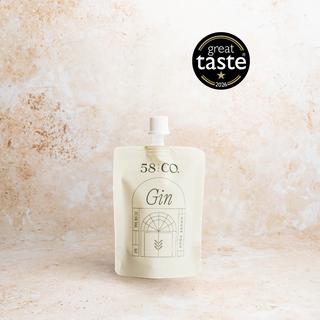 Mini travel pouch of 58 and CO House Pour Gin on a textured beige background with Great Taste Award Badge
