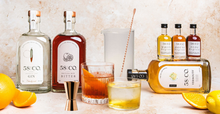 Win a negroni hamper competition with 58 and Co gin, bitter, vermouth, and garnishes on a light background